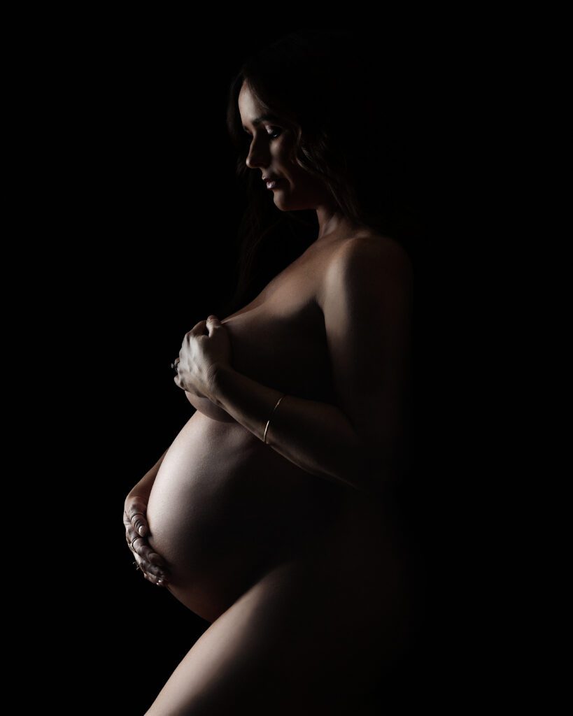 Dramatic low-key maternity silhouette portrait