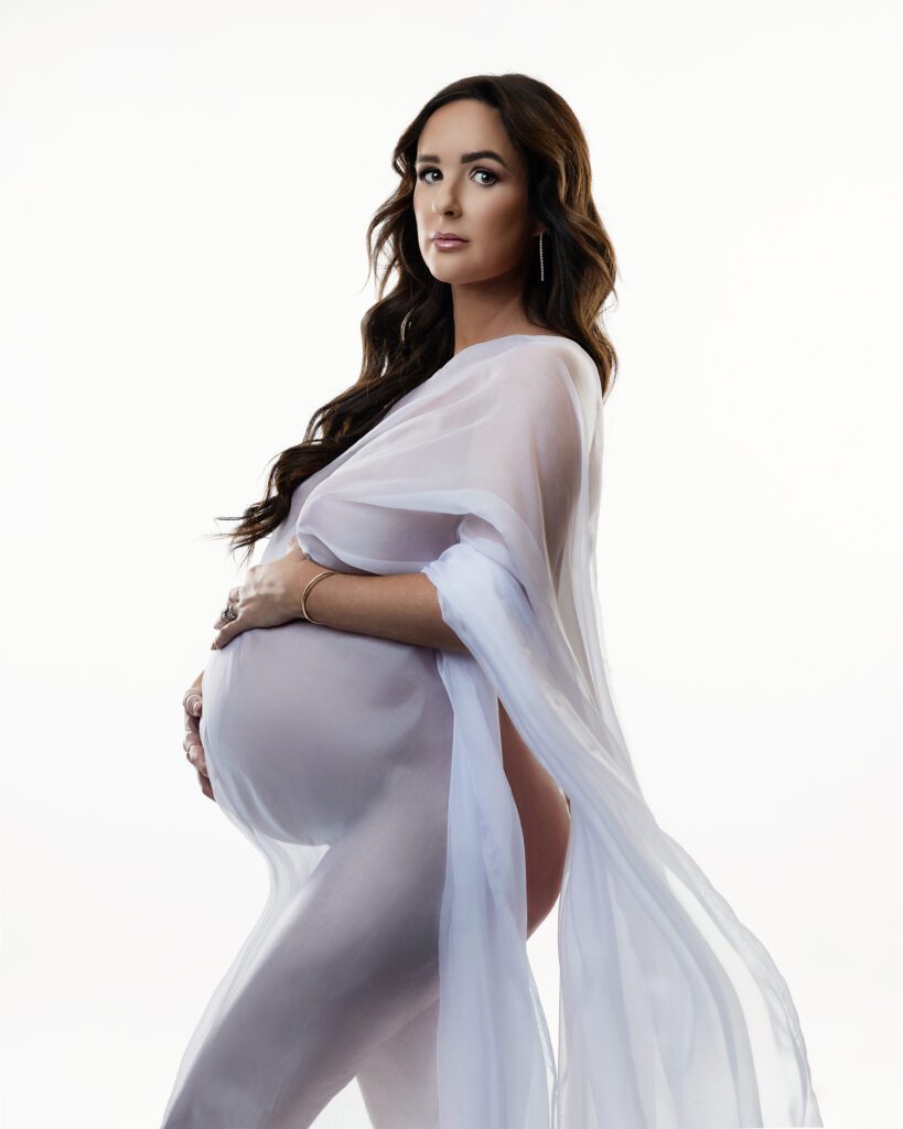 Pregnant woman posing with flowing white fabric during a South Jersey maternity photography session